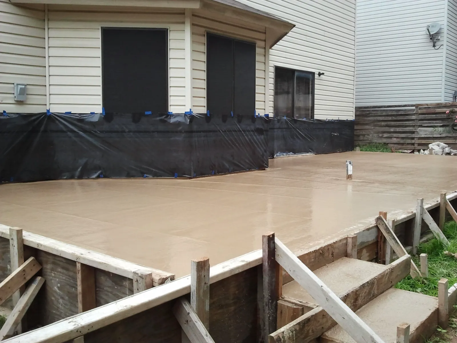 Freshly finished backyard patio slab behind a San Antonio home