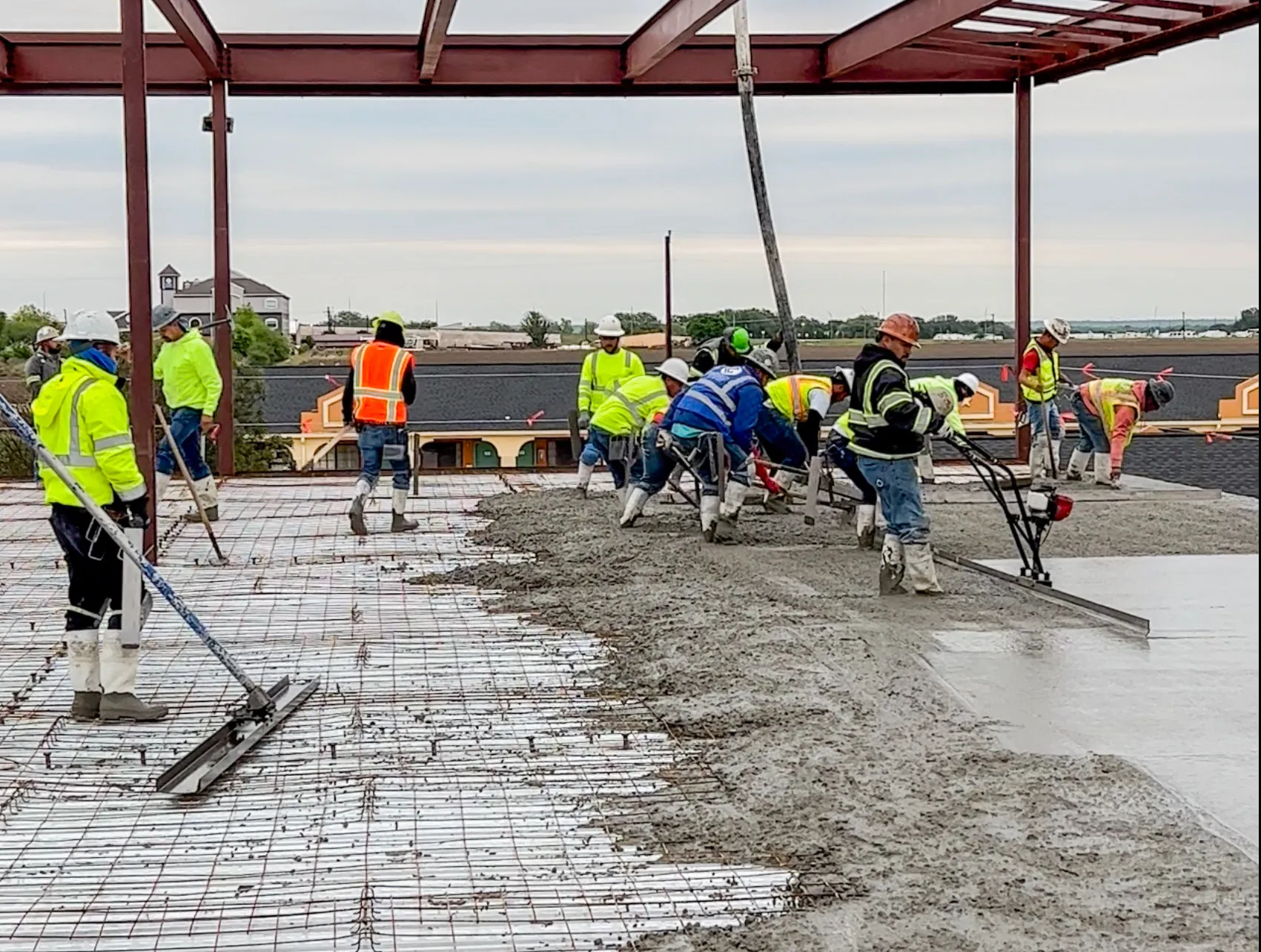 Commercial concrete crew placing a slab inside a steel-framed building
