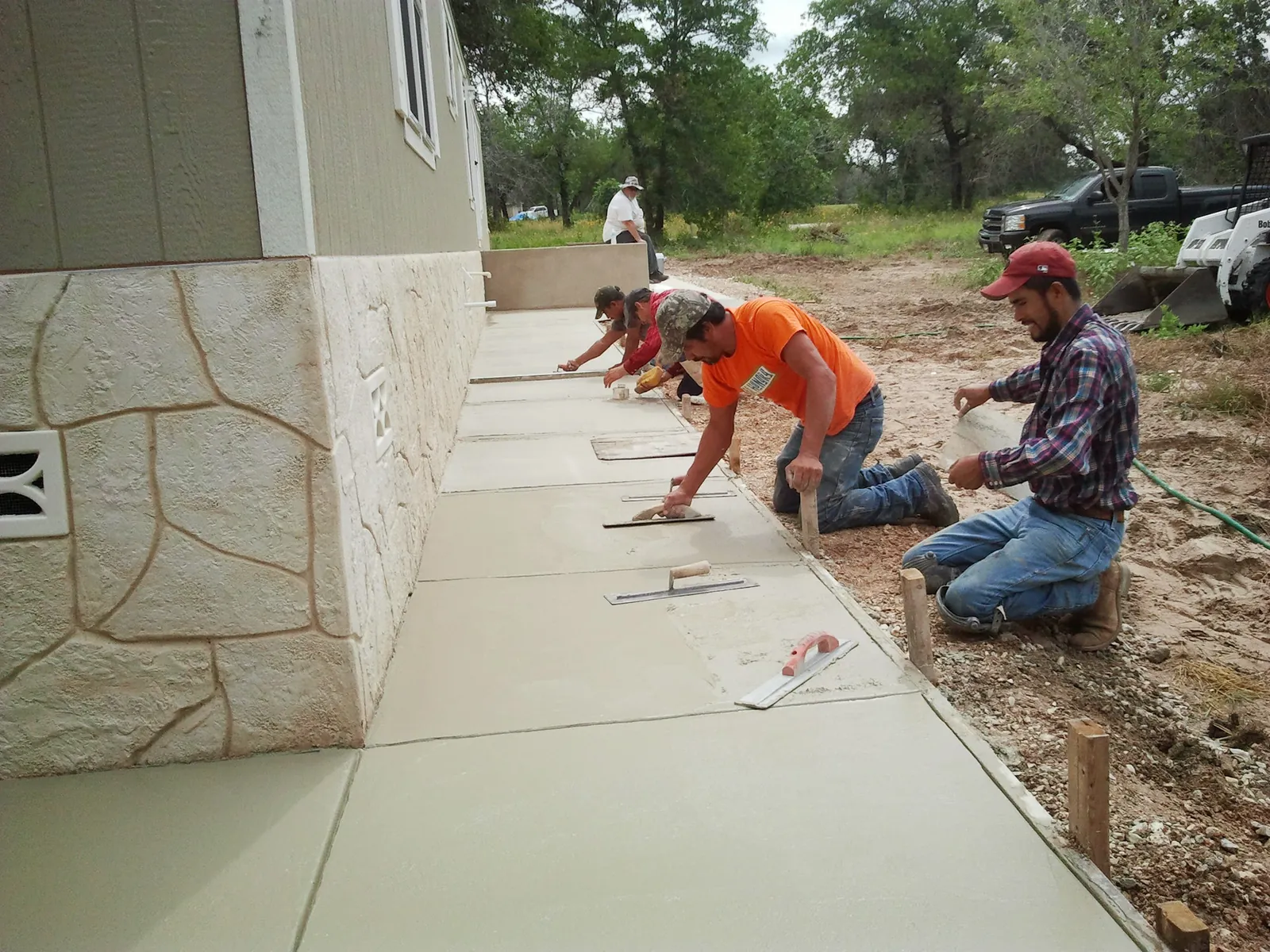 Finishers hand-troweling a new concrete walkway